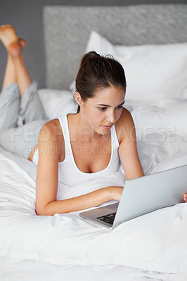 Buy stock photo Woman, lying and laptop on bed for connection, typing and chatting or texting. Female person, technology and computer for conversation in casual outfit, resting and comfortable in bedroom at home