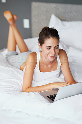 Buy stock photo Woman, lying and laptop with smile in bed for connection, typing and chatting to friends, Female person, technology and computer for conversation in casual outfit, and comfortable in bedroom or home