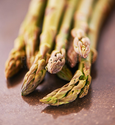 Buy stock photo Vegetable, healthy and asparagus for cooking, food and nutrition at home, house and kitchen with macro on table. Sparrow grass, edible plants and fresh produce for vegan dish, clean eating and diet