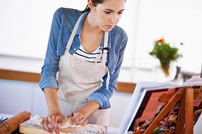 Buy stock photo A young woman baking bread
