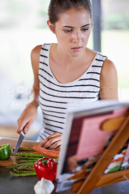 Buy stock photo Shot of a young girl cooking in a kitchen