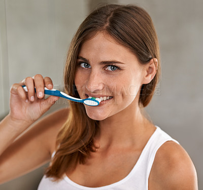 Buy stock photo Portrait of an attractive young woman brushing her teeth