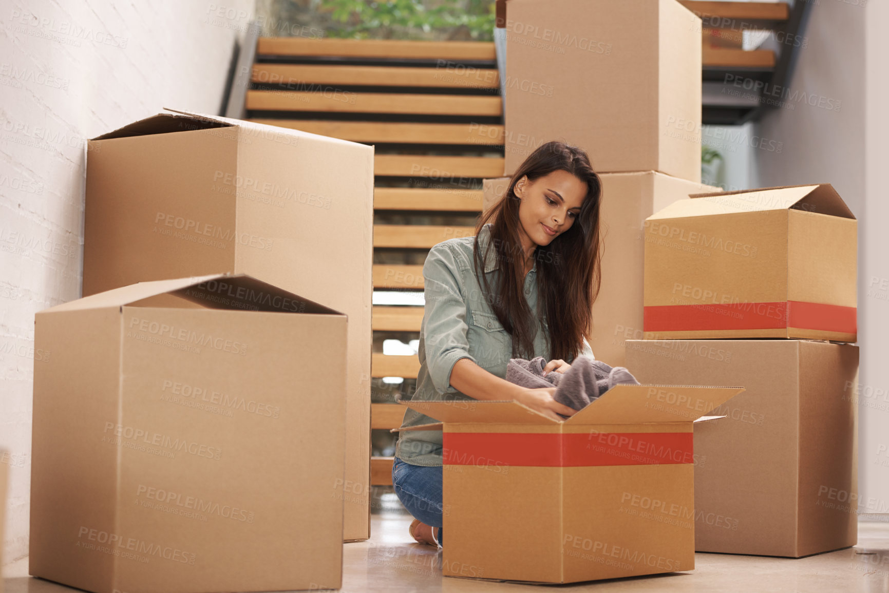 Buy stock photo Young woman packing up boxes in an apartment