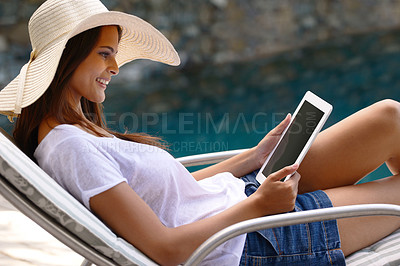 Buy stock photo Holiday, vacation and woman at pool with tablet, hat and relax with happy summer travel on hotel patio. Lounge, digital app and girl with smile, reading and ebook with sunshine, technology and luxury