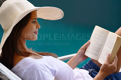Buy stock photo Holiday, reading and woman at pool with book, hat and relax with happy summer travel on hotel patio. Vacation, deck chair and girl with smile, lounge and story with sunshine, weekend or luxury resort