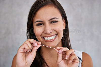 Buy stock photo An isolated portrait of a young woman happily flossing