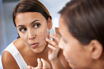 Buy stock photo Pimple, woman and skincare in mirror with pores or face spot or acne on cheek. Home, female person and serious with reflection in bathroom for skin and self care as daily routine for treatment
