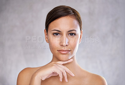 Buy stock photo An isolated portrait of a beautiful young woman touching her face