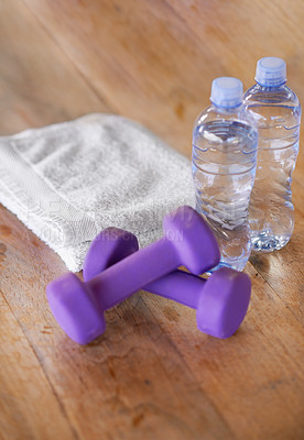 Buy stock photo Closeup, water bottles and towel with dumbbells, ground and exercise with equipment and nutrition. Weights, h2o and cloth with wooden floor or fitness with workout or training with wellness or health