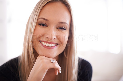 Buy stock photo Portrait of a young woman sitting with her hand on her chin