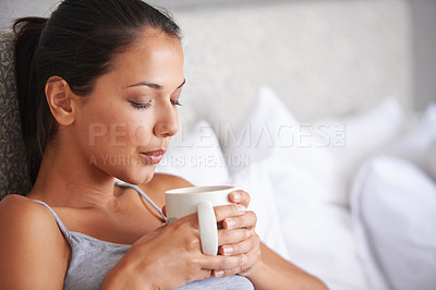Buy stock photo Woman, coffee and bed for relax in morning for wakeup and drink in cup for warm and steam with pillow. Young person with beverage for blow caffeine on weekend for boost in mug with pajamas 