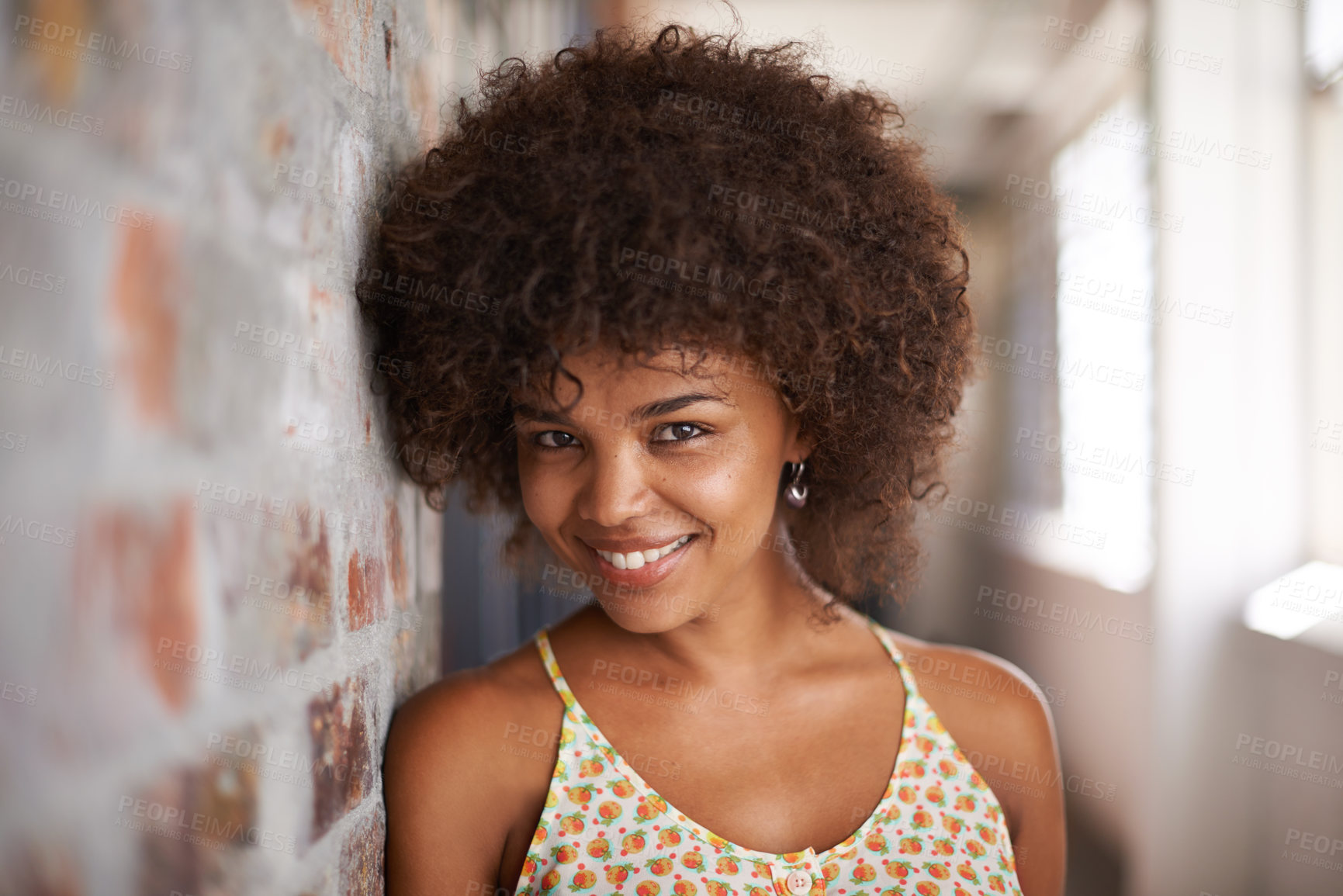 Buy stock photo Portrait, smile and woman by brick wall at university for confidence, education or learning in corridor alone. Face, happy student and girl in hallway of college for profile picture in South Africa