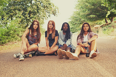Buy stock photo Teen, road and girl with skateboard for hobby in forest with serious look, outdoor and activity in California. Diverse group, friends and sit on street for school holiday or break, fun and together