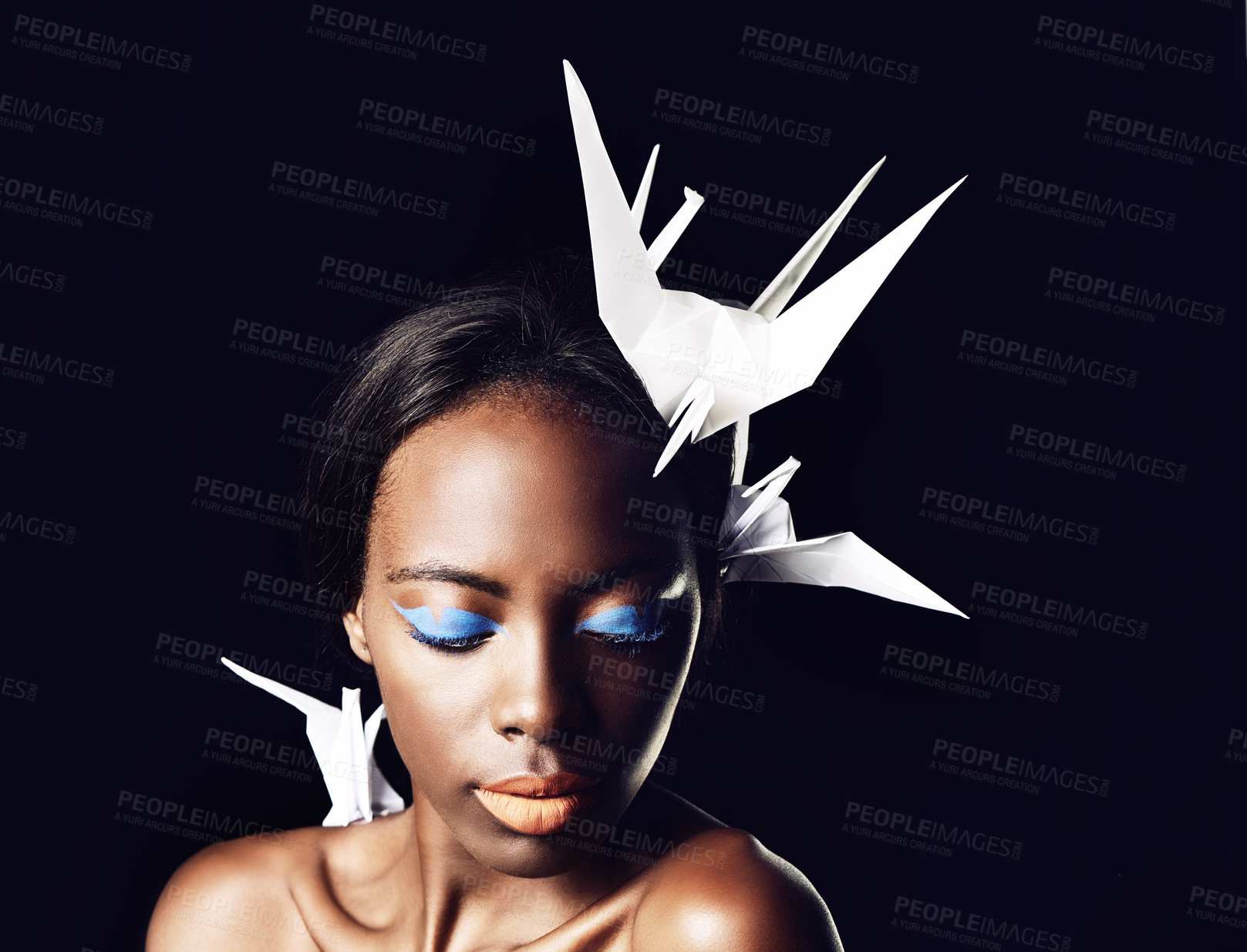 Buy stock photo Black woman, makeup and fine art with cosmetics, origami birds or dove on a dark studio background. Closeup or face of African female person or model with beauty or blue eye shadow on mockup space