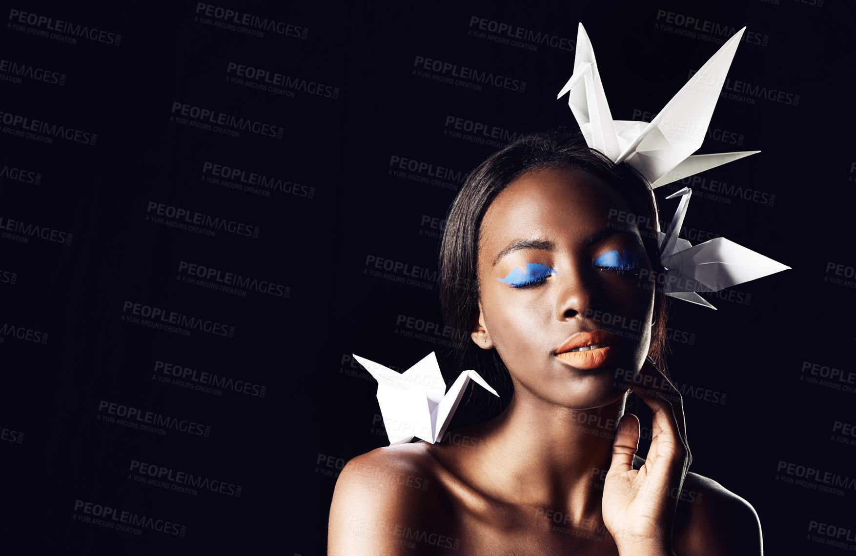 Buy stock photo Black woman, makeup and fine art with beauty, origami birds or cosmetics on a dark studio background. Closeup or face of African female person or model with dove or blue eye shadow on mockup space