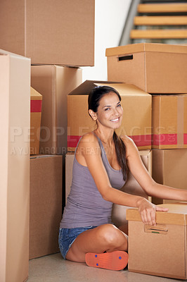 Buy stock photo Shot of a young woman moving into a new home
