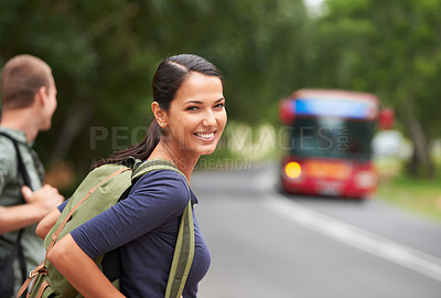 Buy stock photo A beautiful young woman wearing a backpack while waiting for a bus with her husband