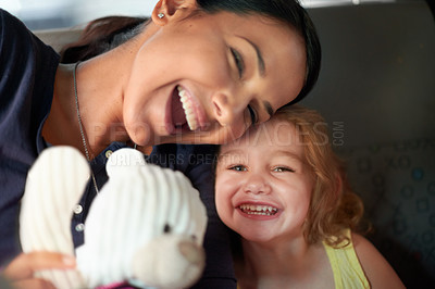Buy stock photo A beautiful mother and daughter keep each other entertained while travelling at the back of a car