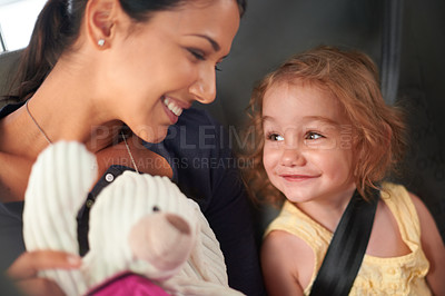 Buy stock photo Taxi, love or mother and daughter in a car for adventure, road trip or bonding with teddy bear games. Happy, family and kid with mom in a backseat of cab with care, trust and safety, travel or fun