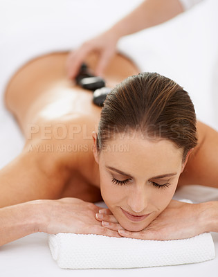 Buy stock photo Relax, hot stone massage and woman at spa for health, wellness and luxury holistic treatment. Self care, peace and girl with natural body therapy, comfort and calm pamper service with hotel therapist