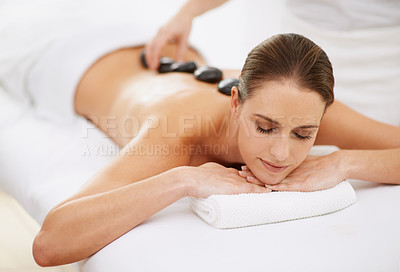 Buy stock photo Relax, hot stone massage and girl at spa for health, wellness and luxury holistic treatment. Self care, zen and woman in natural body therapy, comfort and calm pamper service at hotel with therapist