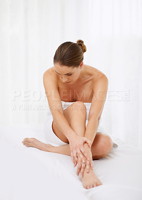 Buy stock photo Shot of a young woman enjoying the feel of her skin