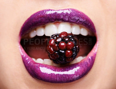 Buy stock photo Closeup of woman lips with purple lipstick, makeup and beauty with shine and vibrant aesthetic, creativity and glow. Fruit between female model teeth, cosmetic product for mouth and cosmetology 
