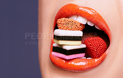 Buy stock photo Cropped shot of a beautiful young woman eating liquorice sweets