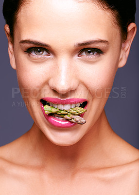 Buy stock photo Woman face, lipstick and vegetable in mouth for beauty, nutrition and vegan cosmetic product. Cruelty free makeup, portrait and asparagus with pink lip gloss for aesthetic on purple background