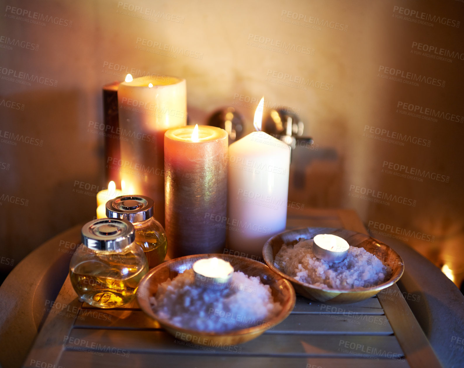 Buy stock photo Spa, candle and oil with salt in room for peace or luxury with aromatherapy to relax, zen and meditation. Aromatic or cosmetic liquid, table and candlelight for mindfulness or wellness and self care.