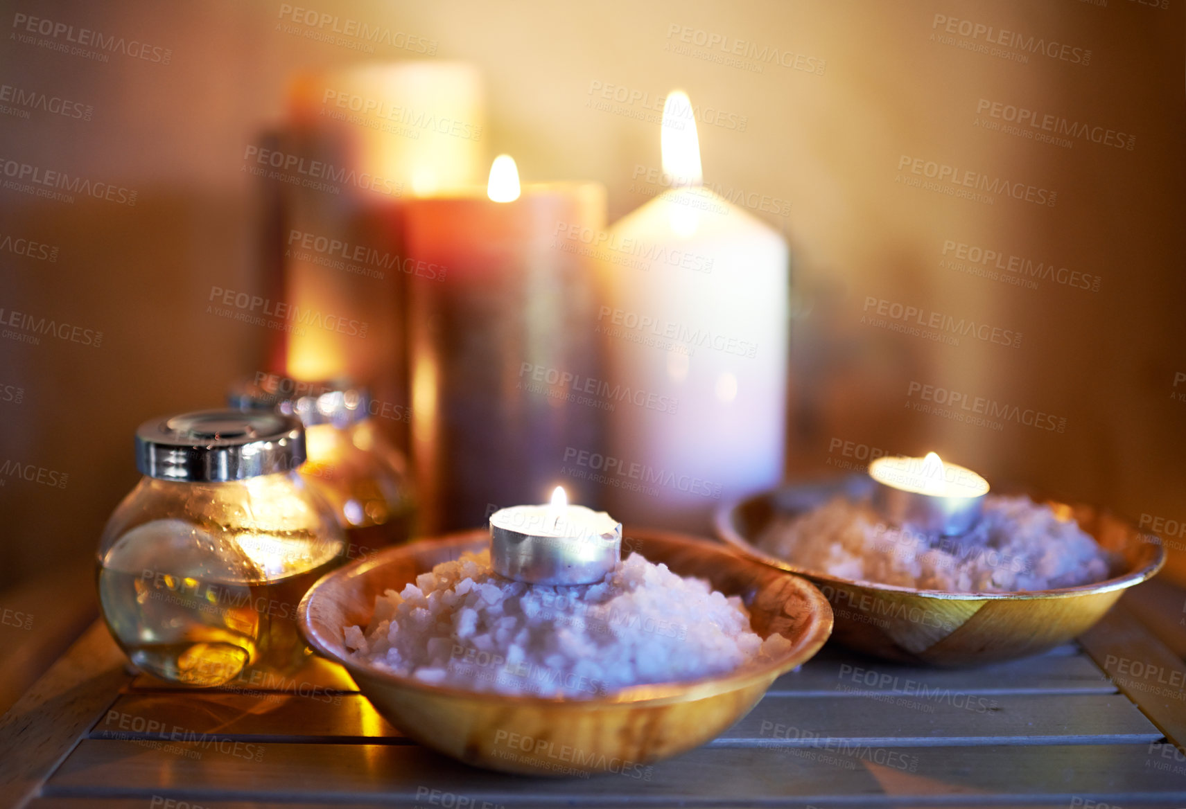 Buy stock photo Spa, candle and oil with salt for peace in room for luxury with aromatherapy to relax, zen and meditation. Aromatic or cosmetic liquid, table and candlelight for mindfulness or wellness and self care