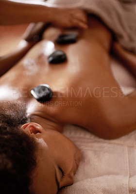 Buy stock photo Hands, hot stone massage and woman in spa with luxury service for muscle, body and relax with peace in resort. Masseuse, hospitality and physical therapy on bed for wellness, zen and natural healing