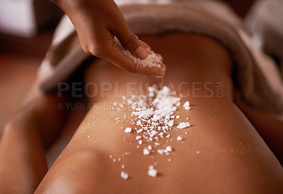 Buy stock photo Shot of a young woman enjoying a salt exfoliation treatment at a spa