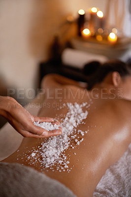 Buy stock photo Shot of a young woman enjoying a salt exfoliation treatment at a spa