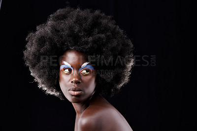 Buy stock photo Studio shot of a beautiful young model wearing colorful eye makeup posing against a black background