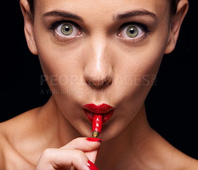 Buy stock photo Beauty, makeup and portrait of woman eating chilli in studio with manicure isolated on black background. Cosmetics, model and face of person with pepper on lips, hot and shocked for healthy skin