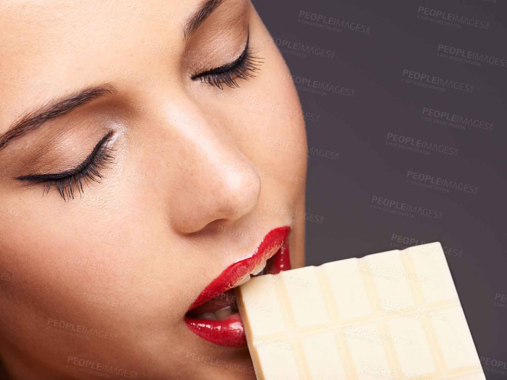 Buy stock photo Beauty, woman and eating with chocolate in studio for lipstick cosmetics, makeup and skincare in gray background. Sweets, closeup and female model for cocoa product, unhealthy snack or bite candy