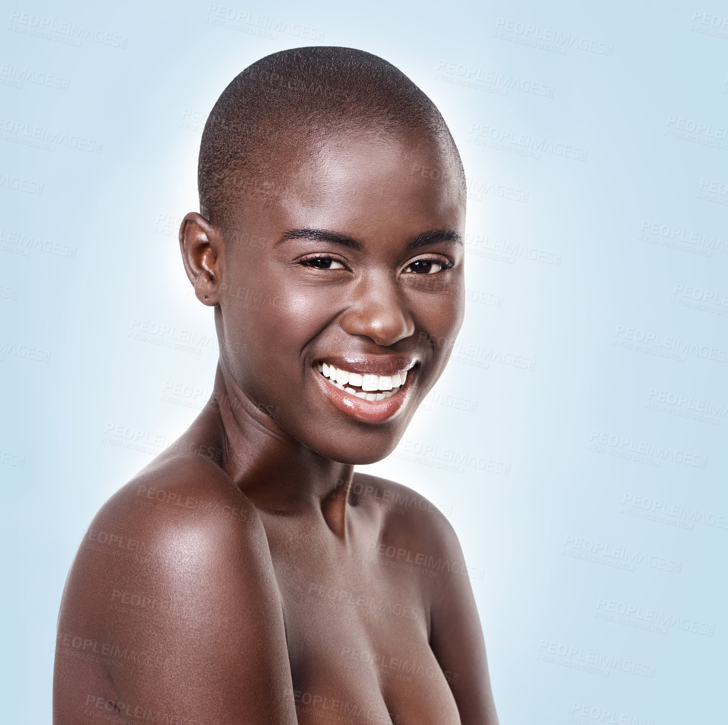 Buy stock photo Portrait, skincare and smile with bald black woman in studio on blue background for natural wellness. Face, beauty and aesthetic with happy young model at spa for cosmetics, facial or dermatology