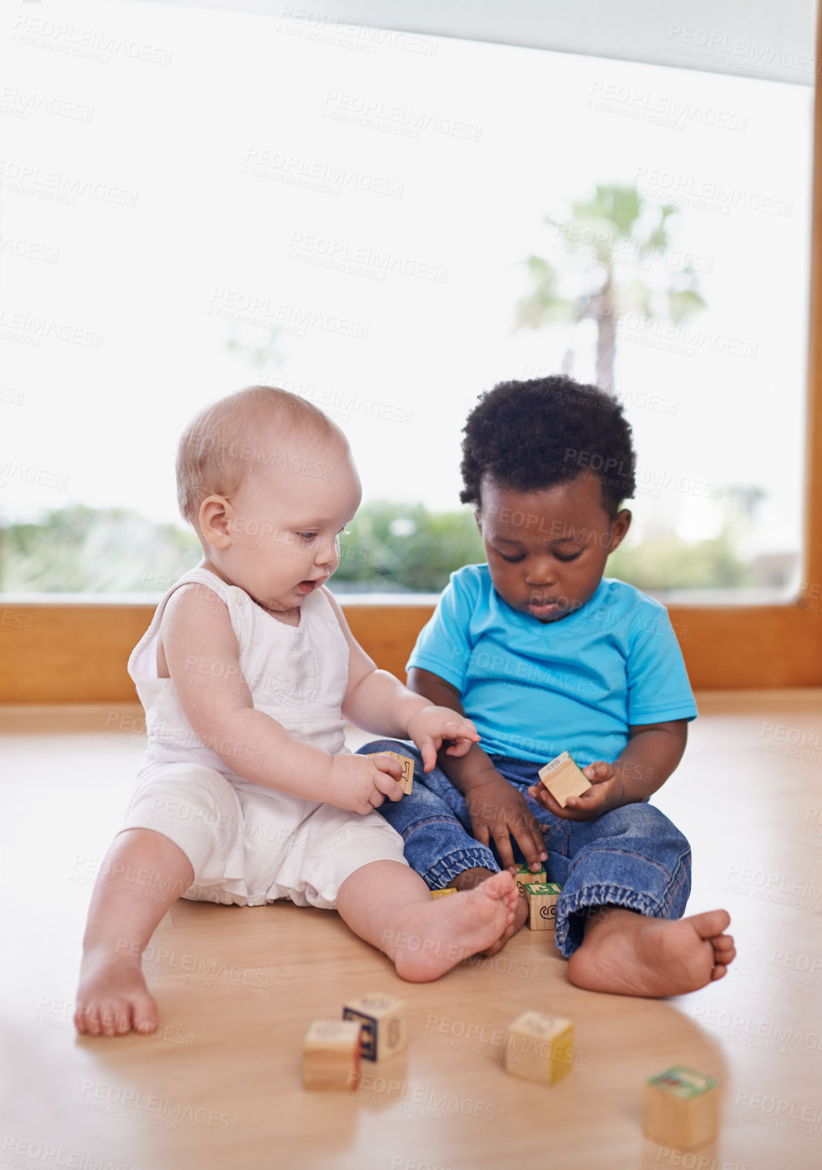 Buy stock photo A shot of two adorable babies playing with building blocks