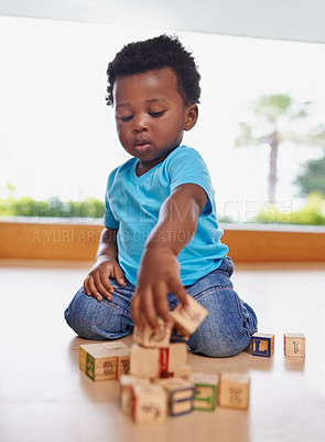 Buy stock photo Full length shot of a baby boy playing with building blocks at home