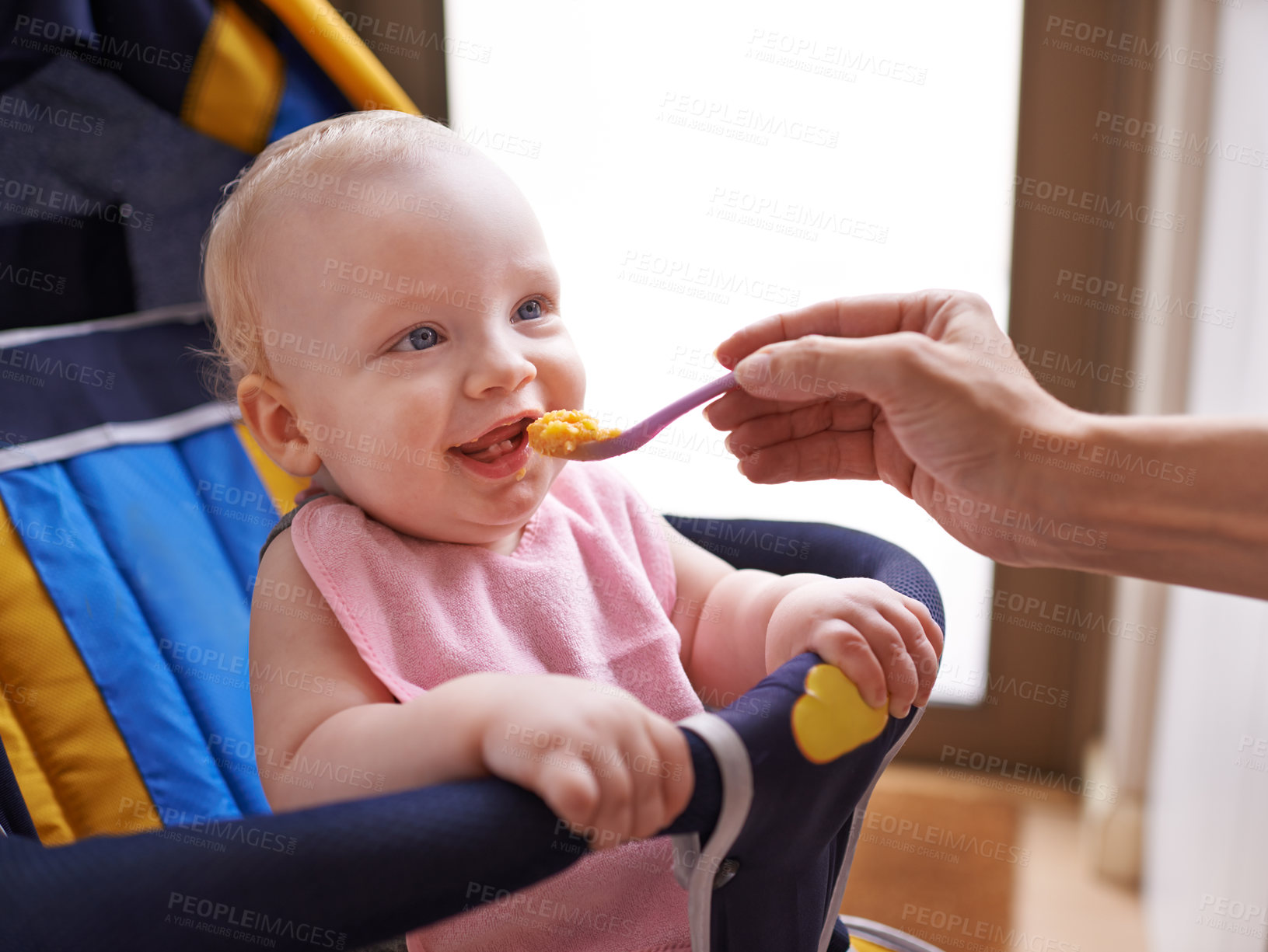 Buy stock photo Baby, hand and feeding food with spoon in chair for nutrition porridge for fiber vitamins or childcare, morning or breakfast. Kid, person and eating meal in home or development growth, dinner or care