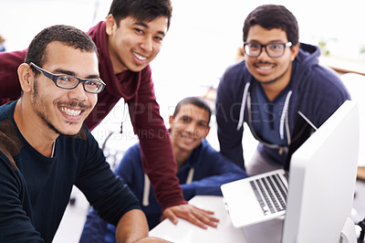 Buy stock photo Cropped shot of young students gathered around a computer