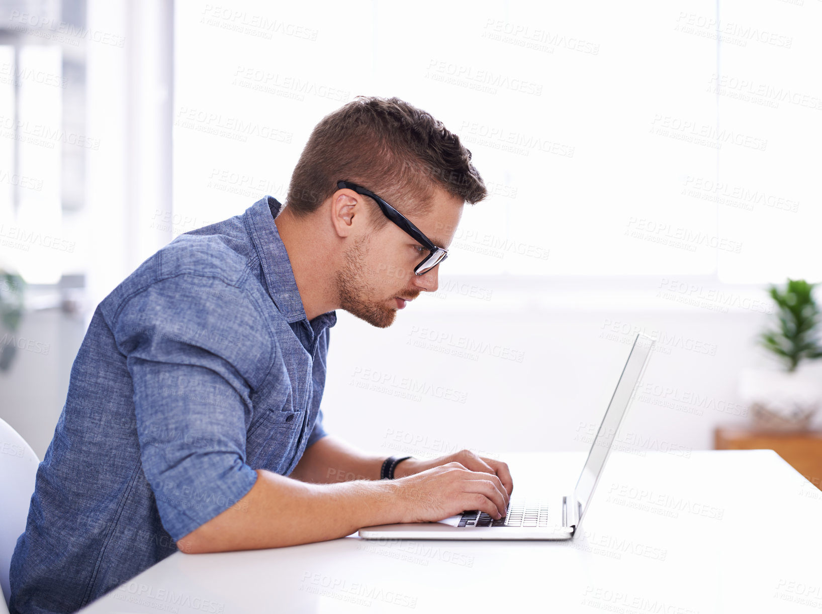 Buy stock photo A young creative businessman using his laptop