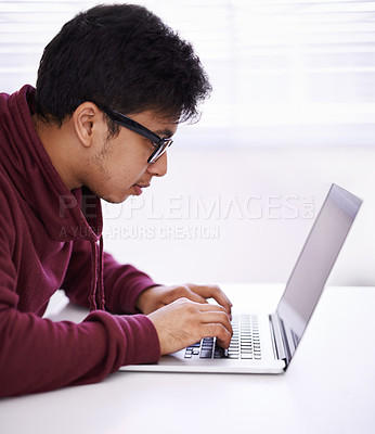 Buy stock photo Man, focus and typing with laptop for research, development or creative startup on table at office desk. Male person, nerd or young geek with vision on computer for email, networking or communication