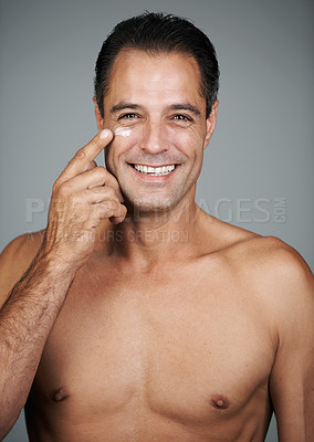 Buy stock photo Mature man, portrait and lotion in studio, beauty and collagen cosmetics for anti aging. Male person, facial treatment and dermatology on gray background, cream and apply moisturizer for hydration