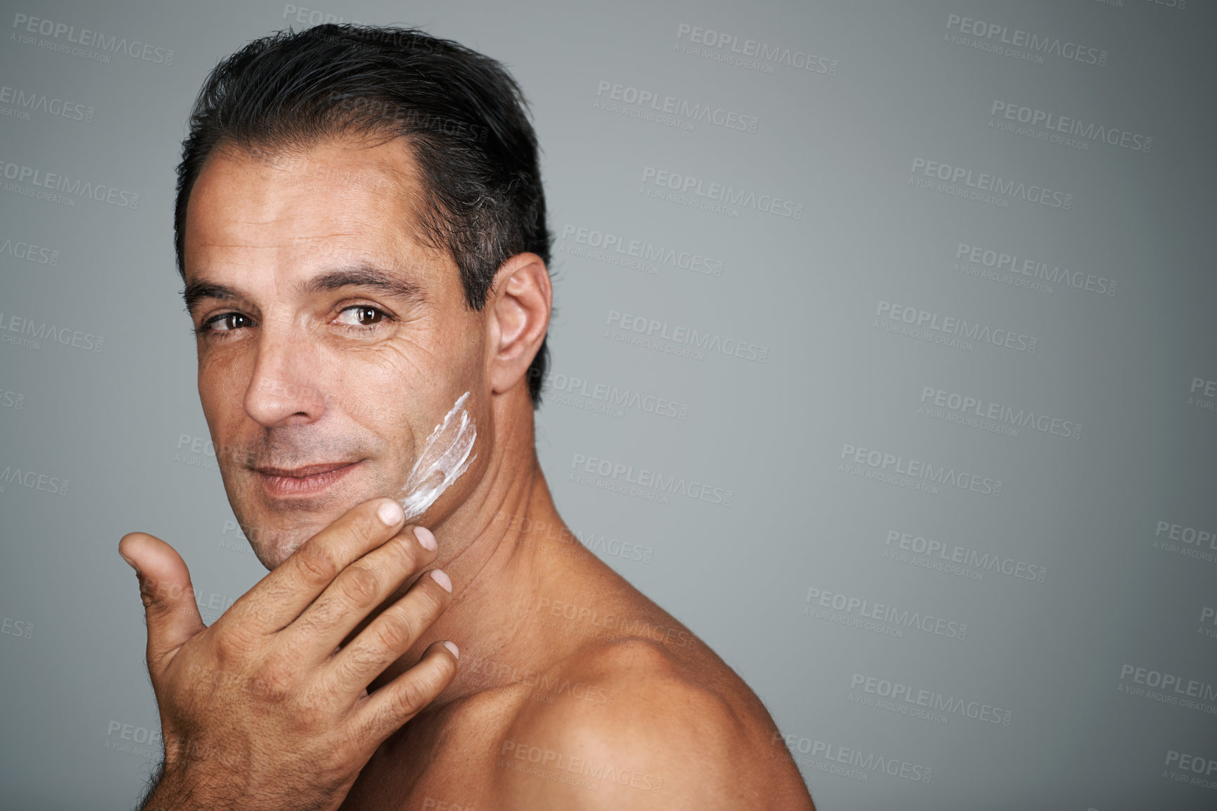Buy stock photo Man, smile and studio with face cream, mature male person with skincare and moisturizing lotion. Dermatology, anti aging product with mockup for facial treatment, natural grooming for wellness