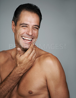 Buy stock photo Studio portrait of a handsome mature man applying moisturizer to his skin