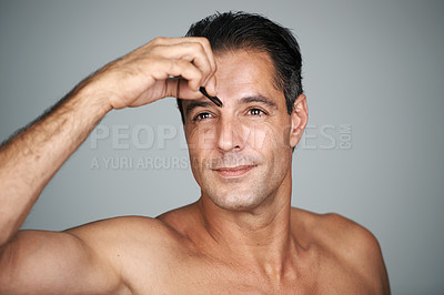 Buy stock photo Man, eyebrows and tweezers for hair removal in studio for grooming treatment, maintenance or grey background. Male person, hand and tool for skincare transformation or wellness, self care or mockup