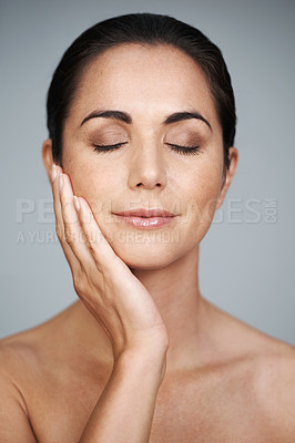 Buy stock photo Beauty, mature and skincare of woman touching face with makeup at studio isolated on gray background. Cosmetics, glow and hand of model in facial treatment for dermatology, anti aging and eyes closed