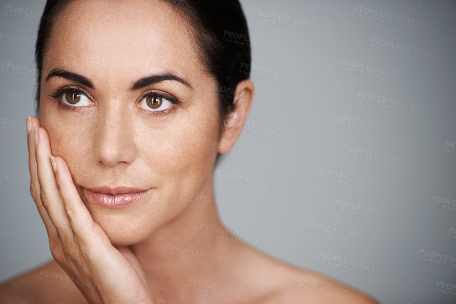 Buy stock photo Face, skincare and mature woman in makeup at studio isolated on a gray background mockup space. Cosmetics, hand and female model in touching skin for dermatology, beauty and thinking of anti aging